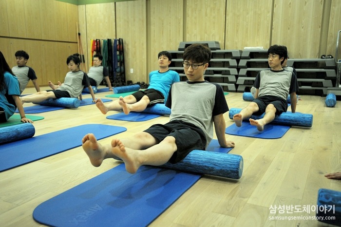 폼 롤러를 이용한 운동을 하는 임직원들