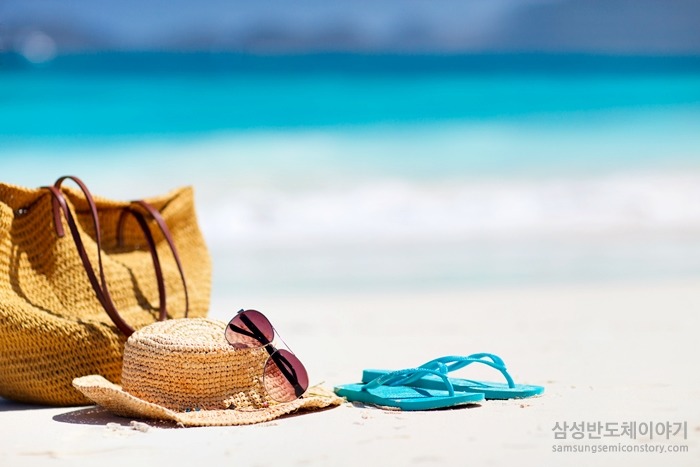 해변의 숄더백과 페도라, 선글라스와 플립플랍
