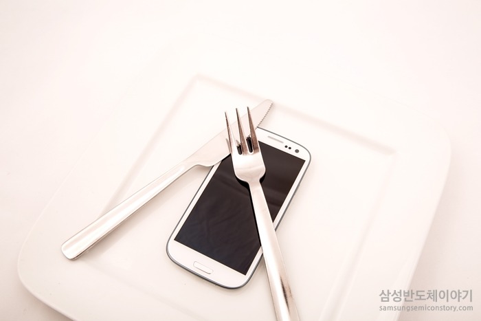 식판에 스마트폰과 식기를 플레이팅한 모습