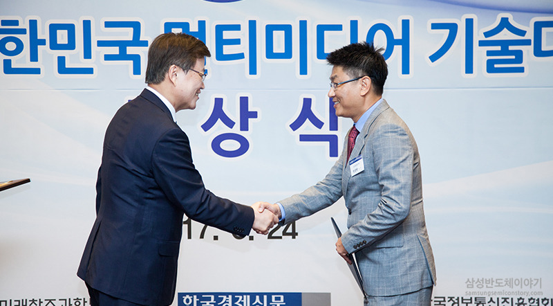 미래창조과학부 최양희 장관(왼쪽)으로부터 상패를 받고 악수하는 삼성전자 한진만 전무