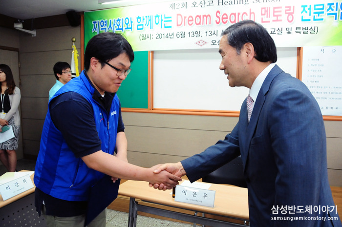 멘토 대표와 오산고등학교 교장 선생님이 악수를 하고 있다