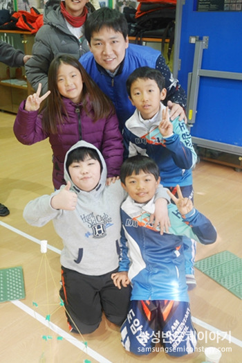 학생들과 기념사진을 찍는 임직원들
