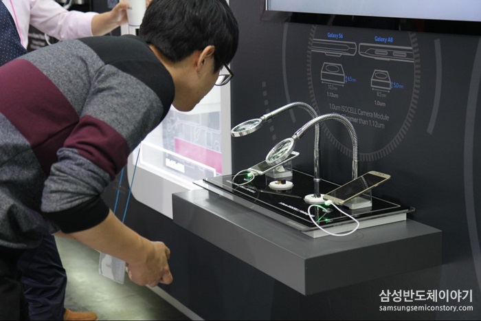스마트폰 이미지 센서를 유심히 관찰하는 방문객